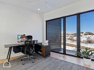 Office with hardwood / wood-style flooring and ceiling fan