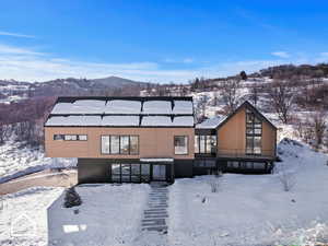 Snow covered house featuring a mountain view