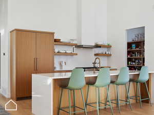 Kitchen featuring a kitchen bar, sink, and light wood-type flooring