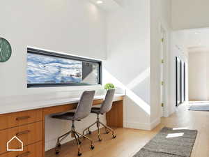 Office featuring light wood-type flooring and built in desk