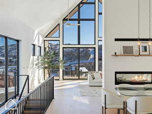 Living room featuring ceiling fan, high vaulted ceiling, and wood-type flooring