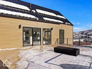 Snow covered patio with a mountain view