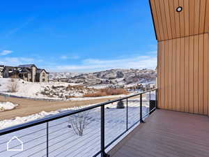 Snow covered back of property with a mountain view