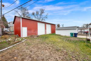 View of outdoor structure with a yard and a garage