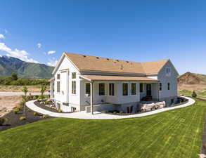 Rear view of property featuring a lawn and a mountain view