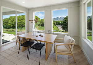 Dining room with a mountain view, a healthy amount of sunlight, and light wood-type flooring