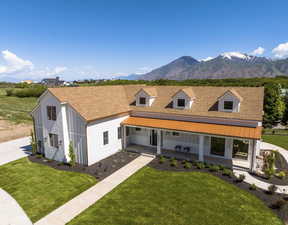 View of front of property with a mountain view and a front lawn