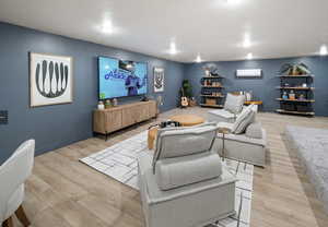 Living room featuring a wall mounted air conditioner and light hardwood / wood-style floors