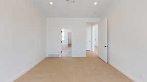 Unfurnished bedroom with light carpet, recessed lighting, visible vents, and baseboards