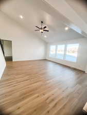 Unfurnished living room featuring high vaulted ceiling, ceiling fan, and light hardwood / wood-style flooring