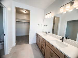 Bathroom with toilet, vanity, and tile patterned floors