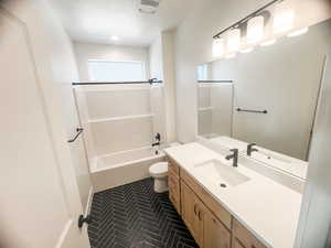 Full bathroom featuring toilet, shower / bath combination, and vanity