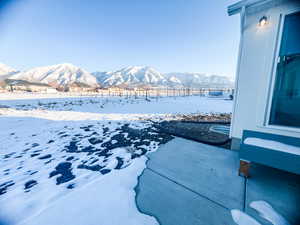 Yard covered in snow featuring a mountain view