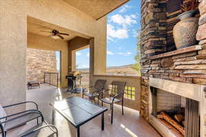 View of patio / terrace with grilling area, ceiling fan, and an outdoor stone fireplace