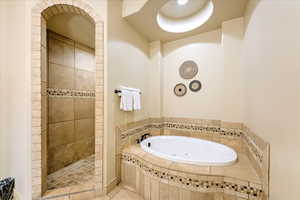 Bathroom with separate shower and tub and tile patterned flooring