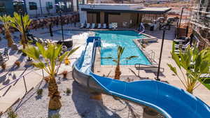 View of pool featuring a water slide and a patio