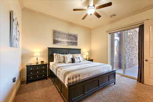 Bedroom featuring access to exterior, carpet floors, ceiling fan, and ornamental molding