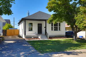 View of front of property with a porch and a front lawn