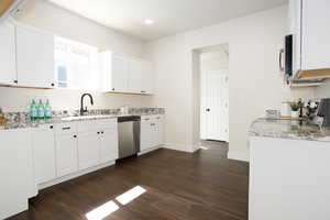 Kitchen with white cabinetry, dark hardwood / wood-style floors, and appliances with stainless steel finishes