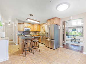 Kitchen featuring sink, stainless steel appliances, backsplash, a kitchen bar, and a kitchen island