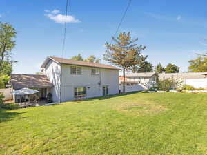 Rear view of house with a patio area and a yard