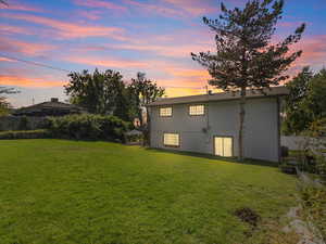 Back house at dusk with a lawn