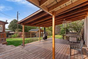 Wooden deck with a yard, grilling area, and ceiling fan