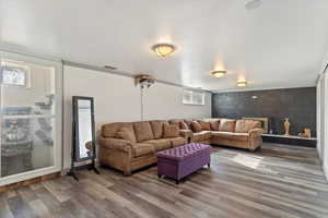 Living room featuring a wealth of natural light, hardwood / wood-style floors, and crown molding