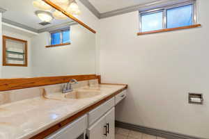 Bathroom with crown molding, tile patterned flooring, and vanity