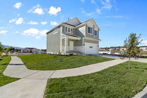 View of front of house featuring a front yard and a garage