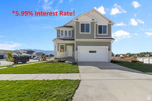 View of front facade featuring a garage and a front yard