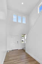 Foyer with a towering ceiling and light wood-type flooring