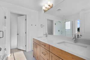 Bathroom with tile patterned floors, vanity, and walk in shower