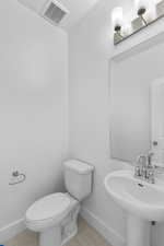 Bathroom with tile patterned floors, sink, and toilet