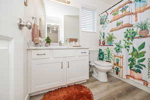 Main Bathroom with vanity, hardwood / wood-style flooring, and toilet