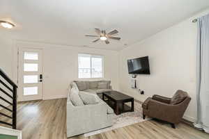 Living room with ceiling fan and light wood-type flooring