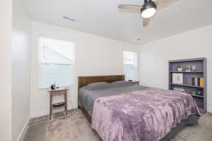 Primary Carpeted bedroom with a textured ceiling and ceiling fan