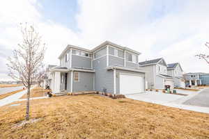 View of property featuring a garage and a front/side yard