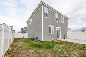 Back of property featuring a yard, a patio, and central AC unit