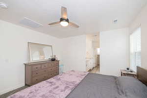 Primary Carpeted bedroom with connected bathroom, ceiling fan, and a textured ceiling