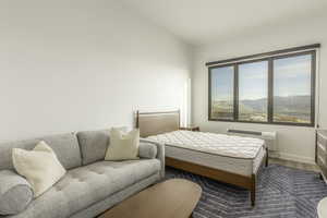 Bedroom featuring a wall unit AC, a mountain view, and wood-type flooring