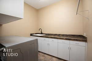 Washroom featuring cabinets, sink, and washer / dryer