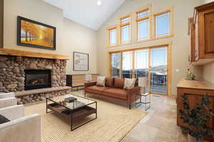 Living room featuring a fireplace and high vaulted ceiling