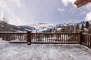 Snow covered deck with a mountain view