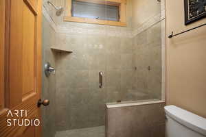 Bathroom featuring an enclosed shower and toilet