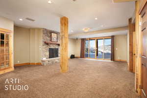 Unfurnished living room with a fireplace, a mountain view, and carpet floors