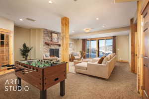 Rec room featuring a stone fireplace, light carpet, and french doors