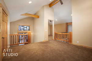 Corridor with carpet and lofted ceiling with beams