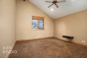 Spare room featuring carpet flooring, vaulted ceiling with beams, and ceiling fan