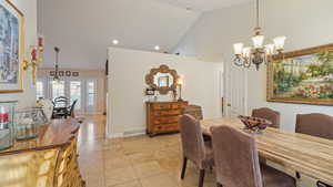 Dining area featuring a chandelier and high vaulted ceiling